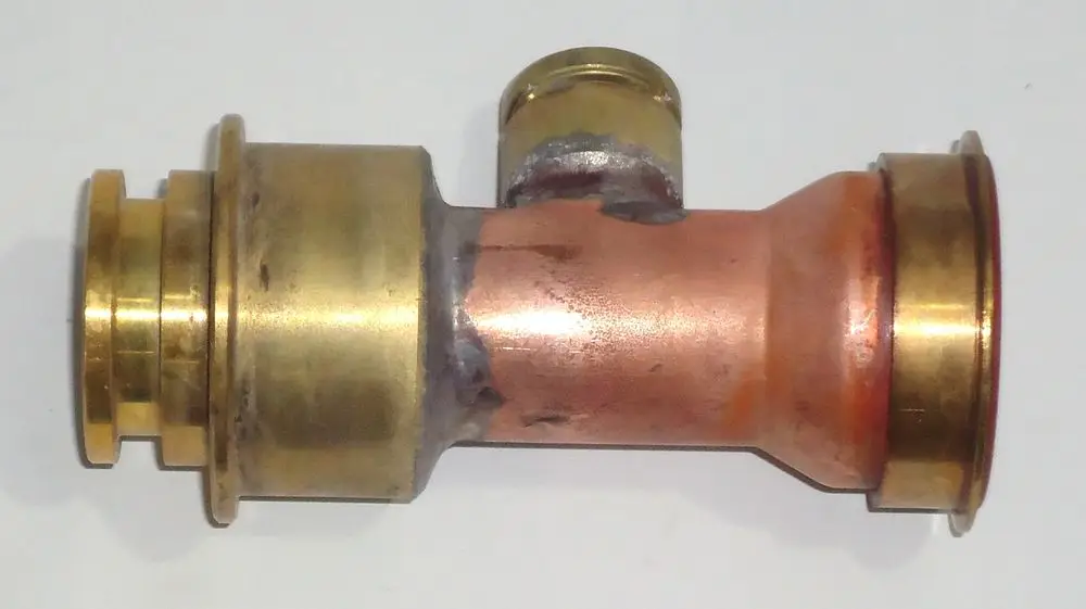 Kupfer-Wasserrohr mit Metallverbindungsstücken, möglicherweise für ein Heizsystem. Produkt könnte für Daikin-Anwendungen geeignet sein.